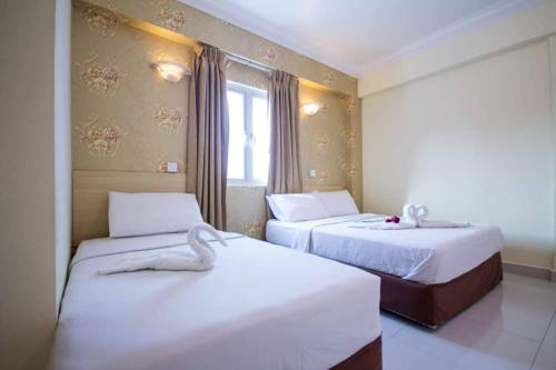 Hotel Sea Princess في تيلوك بهانج: غرفة فندقية بسريرين ونافذة