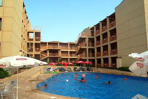 a swimming pool in a hotel with people in it at Апартамент Blue sky in Sinemorets