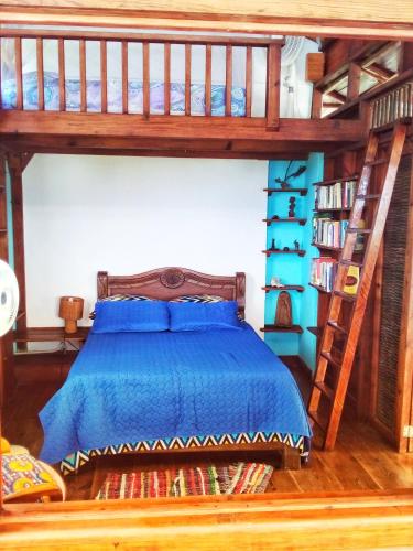 a bedroom with a bed with a blue comforter at Windy View Guest House in Providencia