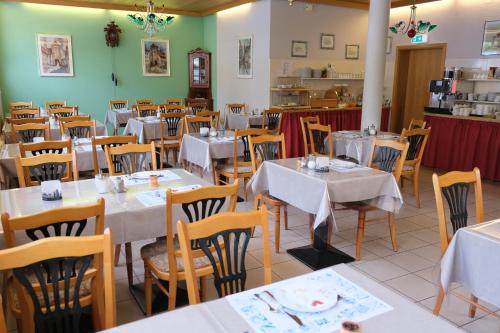 a restaurant with white tables and chairs and green walls at Hotel im Klosterring in Villingen-Schwenningen