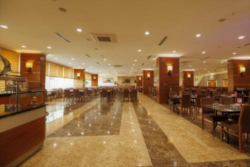 a restaurant with tables and chairs in a room at Ramada By Wyndham Cappadocia in Ortahisar