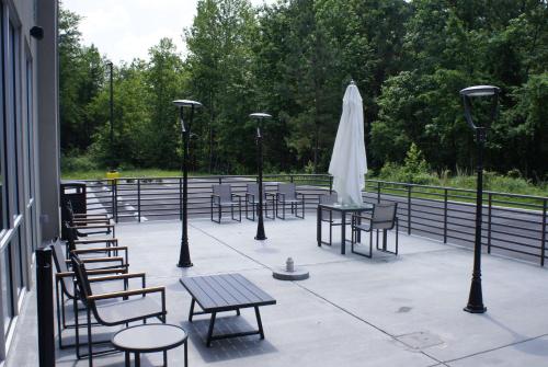 a patio with tables and chairs and a white umbrella at La Quinta Inn & Suites by Wyndham Manchester - Arnold AFB in Manchester