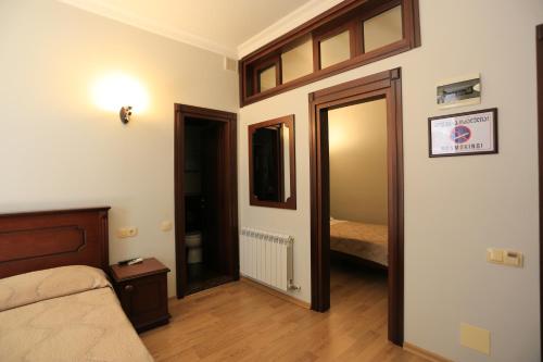 a room with a bedroom with a bed and a mirror at Eiffel Hotel in Batumi