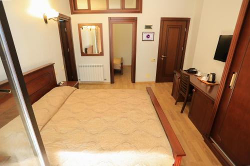 a living room with a bed and a television at Eiffel Hotel in Batumi