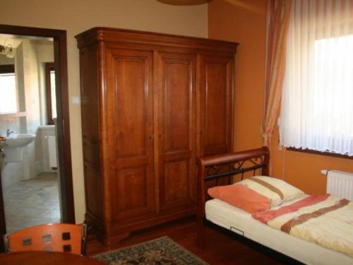 1 dormitorio con armario de madera y cama en Apartament II Marysieńka en Kąty Rybackie