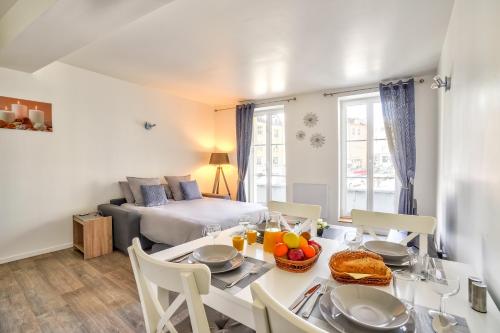 a living room with a dining table and a bed at Top Destination Pontoise in Pontoise