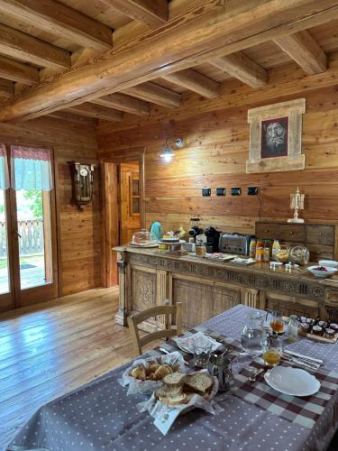 una cocina con mesa en una cabaña de madera en LA PIANA DAL SAS, en Gravellona Toce