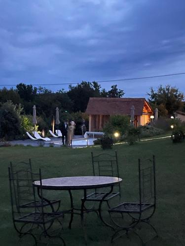 a table and chairs in a yard at night at Le Clos Des Buis Gîte de Charme Le Loft in Cazals