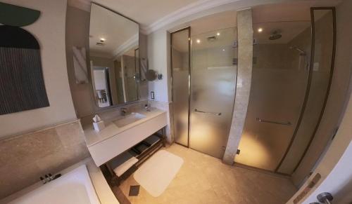 y baño con ducha y lavamanos. en 1 Bedroom Suite @ The address Golf Marassi Resort, en El Alamein