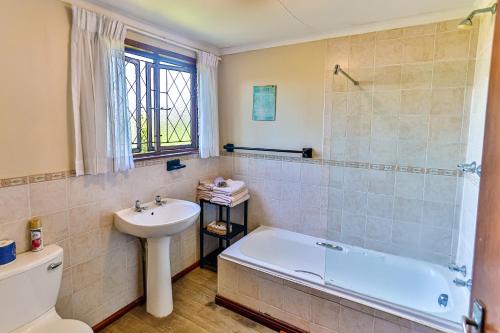 łazienka z umywalką, wanną i toaletą w obiekcie Zuider Zee Guest House w mieście Ballito