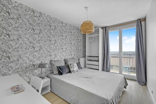 - une chambre avec un lit et une grande fenêtre dans l'établissement Le Jolimont T4 et vues spectaculaires sur la ville, à Toulouse