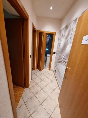 pasillo con puerta y suelo de baldosa en Alloggio Silva, en Gorizia