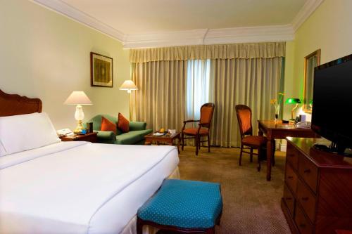 チェンナイにあるル ロイヤル メリディアン チェンナイのベッドとリビングルームが備わるホテルルームです。