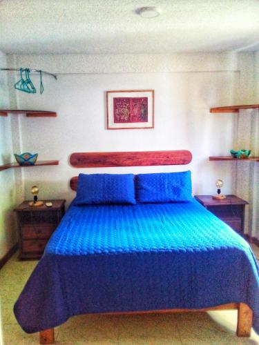 a bedroom with a blue bed with two blue pillows at Windy View Guest House in Providencia