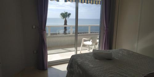 a bedroom with a bed and a view of the ocean at Apartamentos Don Pepe in Torremolinos