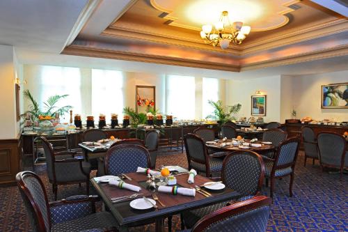 a restaurant with tables and chairs in a room at Le Royal Meridien Chennai in Chennai