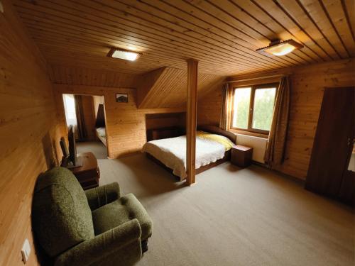 ein Schlafzimmer mit einem Bett und einem Stuhl in einem Zimmer in der Unterkunft Darynka in Jaremtsche