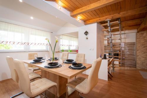 a kitchen and dining room with a wooden table and chairs at Emmy i Alice in Josipdol