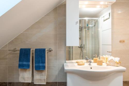 La salle de bains est pourvue d'un lavabo et de serviettes bleues. dans l'établissement Emmy i Alice, à Josipdol