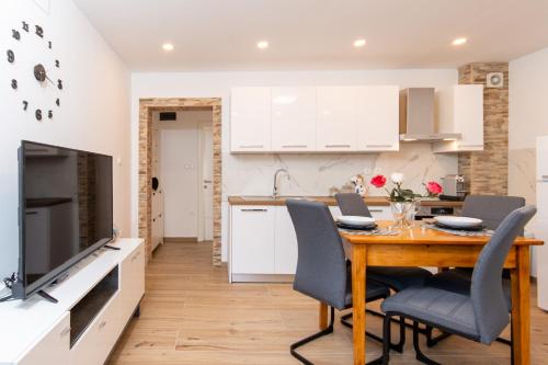 a kitchen and dining room with a wooden table and chairs at Emmy i Alice in Josipdol