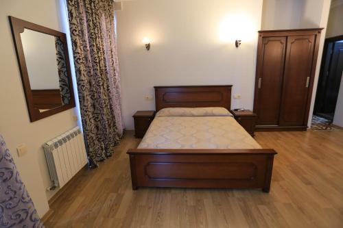 a bedroom with a bed and a mirror at Eiffel Hotel in Batumi