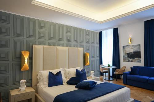 a bedroom with a bed and a blue couch at Màs Boutique Hotel Rome in Rome
