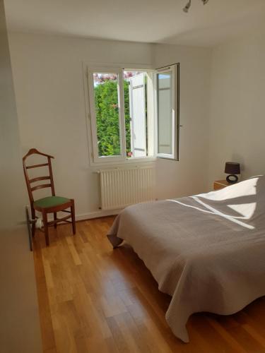 1 dormitorio con 1 cama, 1 silla y 1 ventana en LA ROCHELLE classé 3 étoiles, en Nieul-sur-Mer