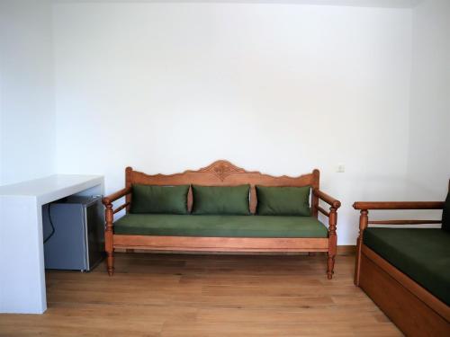 a green couch in the corner of a room at ΤΟ ΚΑΜΙΝΙ ΤΟΥ ΜΗΛΑ in Kithnos