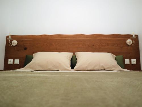 a bed with a wooden headboard and two pillows at ΤΟ ΚΑΜΙΝΙ ΤΟΥ ΜΗΛΑ in Kithnos