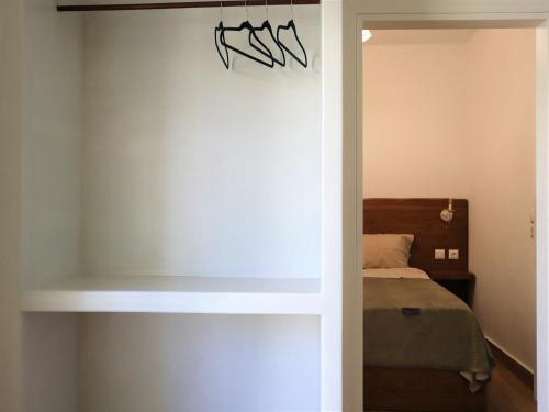 1 dormitorio con cama y pared en ΤΟ ΚΑΜΙΝΙ ΤΟΥ ΜΗΛΑ en Kithnos