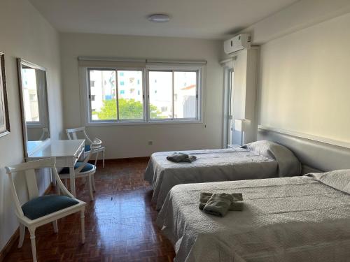 pokój hotelowy z 2 łóżkami, stołem i krzesłami w obiekcie ONAR apartment w Larnace