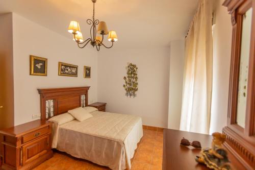 - une chambre avec un lit et un lustre dans l'établissement La Alondra, à Arroyo Frío