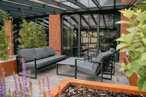 a patio with two chairs and a couch at Loft apartmány FABRIKA in Vyhne