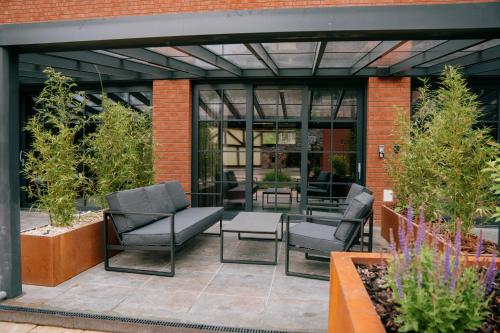 a patio with chairs and tables in a building at Loft apartmány FABRIKA in Vyhne