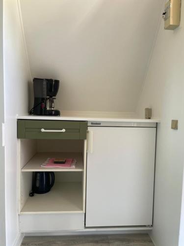 a kitchen with a white refrigerator and a cupboard at Løgstør Camping in Løgstør