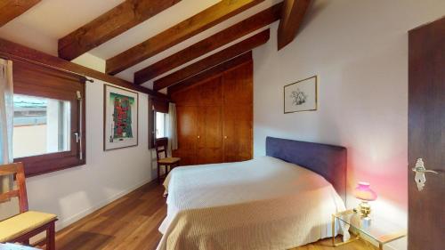 a bedroom with a bed in a room with wooden ceilings at Abitaziun Furtschellas 8 - Sils Maria in Sils Maria