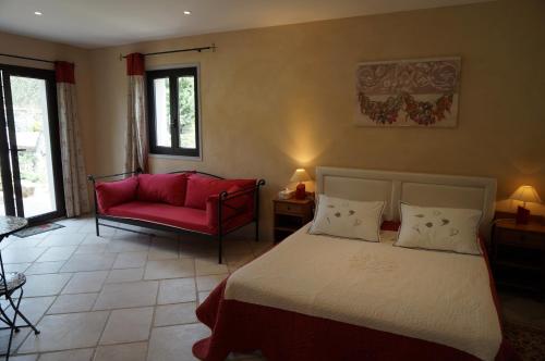 1 dormitorio con 1 cama y 1 sofá rojo en Chambre d'Hôtes Domaine Pero Longo en Sartène