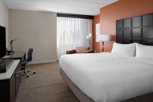 a hotel room with a large bed and a desk at Renaissance Indianapolis North Hotel in Carmel