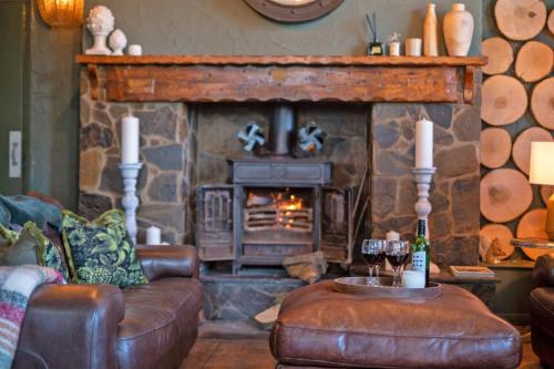 een woonkamer met een open haard, een bank en een tafel bij Waterfall Country Escape Entire Venue Sleeps 19 - Brecon Beacons National Park Wales in Coelbren