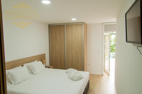 1 dormitorio con 1 cama blanca y TV en Suite 5, en Pinhão