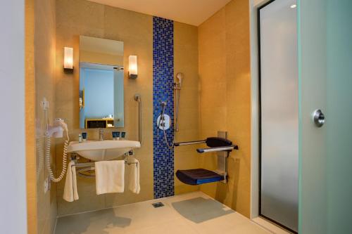 a bathroom with a sink and a shower at Four Points by Sheraton Chennai OMR in Chennai