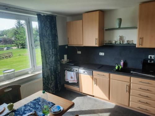 a kitchen with a table and a large window at Ferienwohnung Wiesenblick in Seiffen in Kurort Seiffen