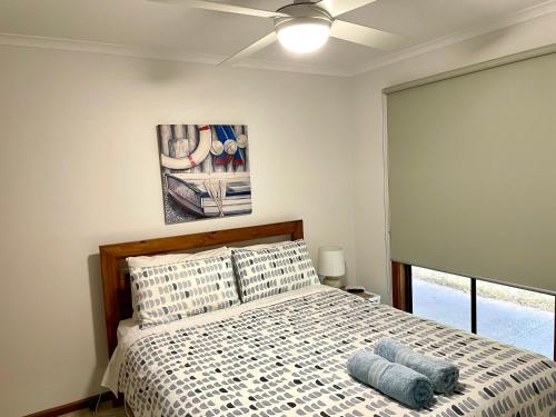 a bedroom with a bed and a ceiling fan at Fareview Beach House in Emu Bay