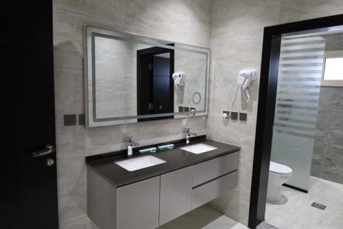 قمم بارك النماص Qimam Park Hotel 6 في النماص: حمام مع حوض ومرآة ومرحاض
