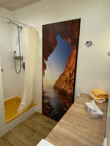 a bathroom with a shower with a painting of a cliff at Schumacher's Landhaus - Bücherhotel in Friedeburg