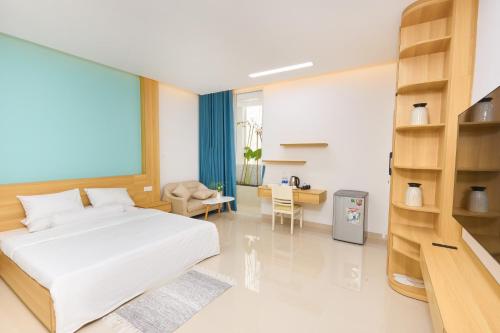 a bedroom with a white bed and a desk at Truc Home in Danang