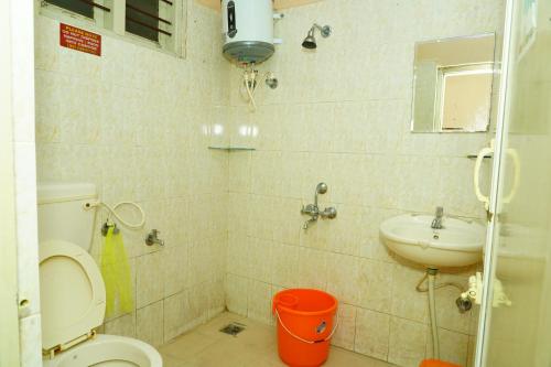 a bathroom with a toilet and a sink at Holidayincoorg Brick lane in Madikeri