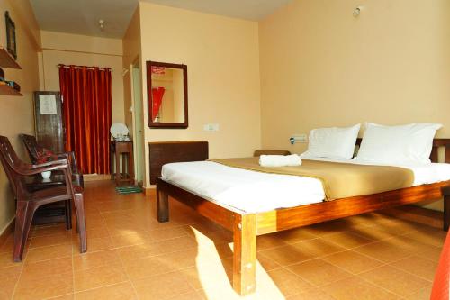 a bedroom with a bed and a table and a chair at Holidayincoorg Brick lane in Madikeri