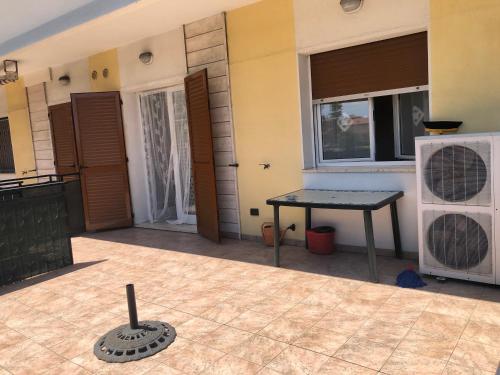 a patio with a table and a window in a house at ONDA BLU in Diano Marina