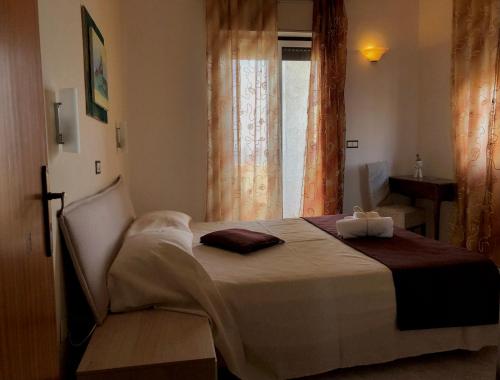 una camera con un letto in una stanza con una finestra di Hotel Costa Azzurra a Briatico